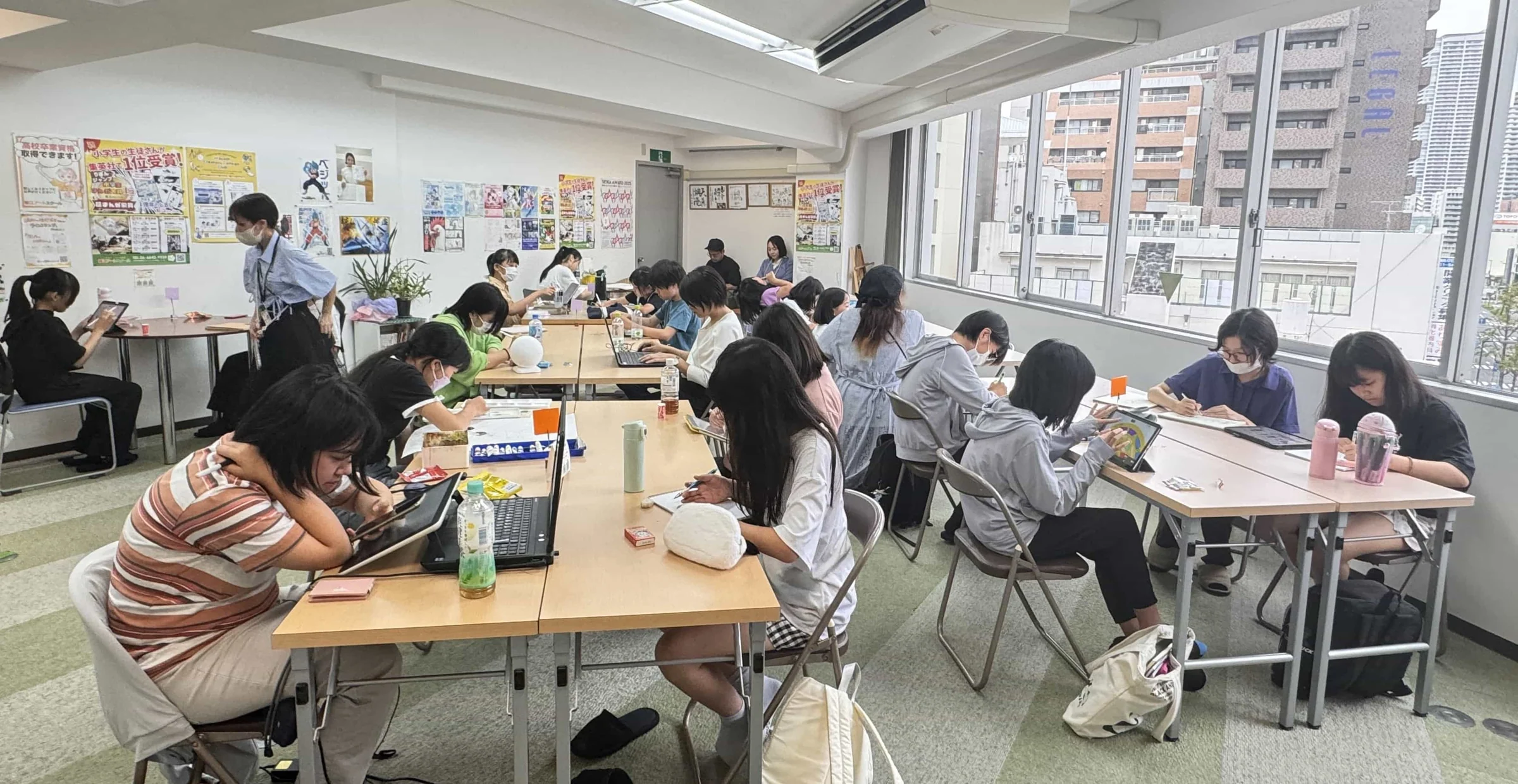 明るい教室で、講師と受講生がそれぞれの作品づくりに取り組む様子