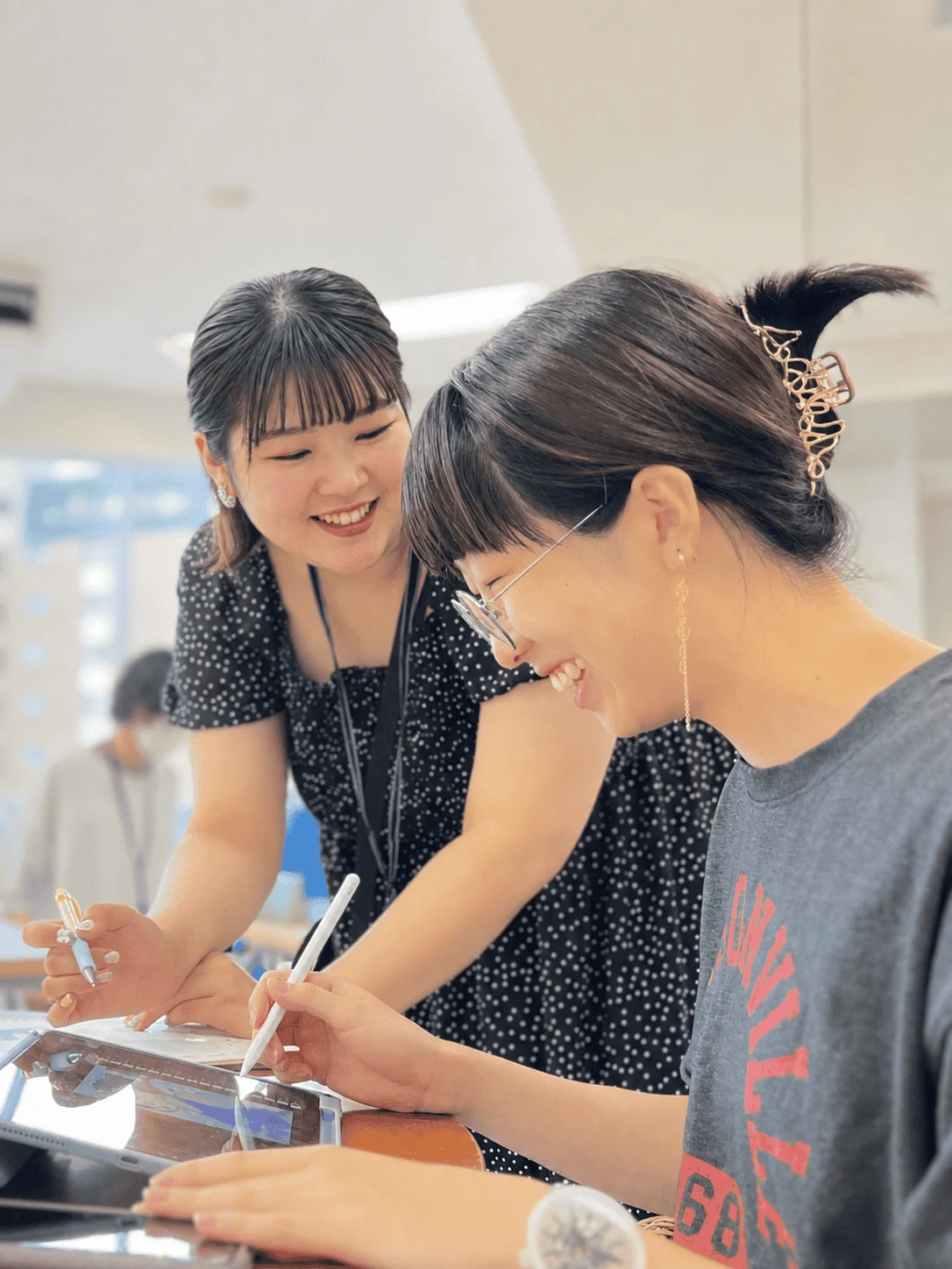タブレットで描く生徒にアドバイスする講師
