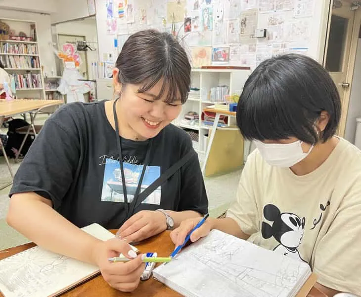 教室で受講生の作品に寄り添ってアドバイスする講師